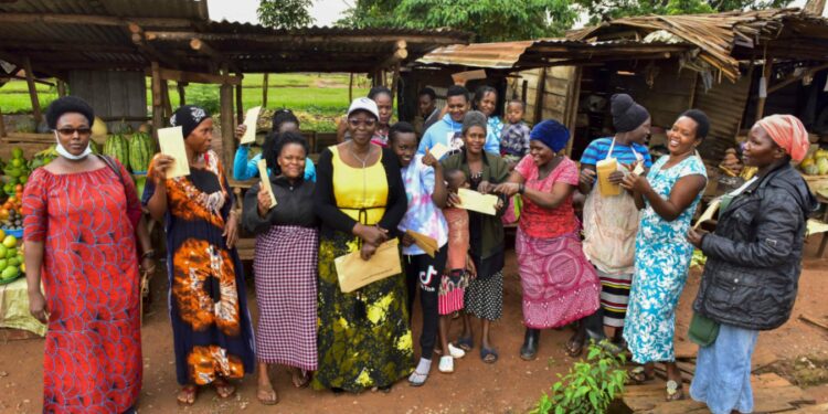 The State House Political desk's Princess Pauline Nassolo and Flora Kabibi in a group photo with market vendors of Nakwero market in Nakwero zone B village, Kimanyi parish, Kiira Municipality, Wakiso District on 8th November 2022. Photo by PPU/ Tony Rujuta.