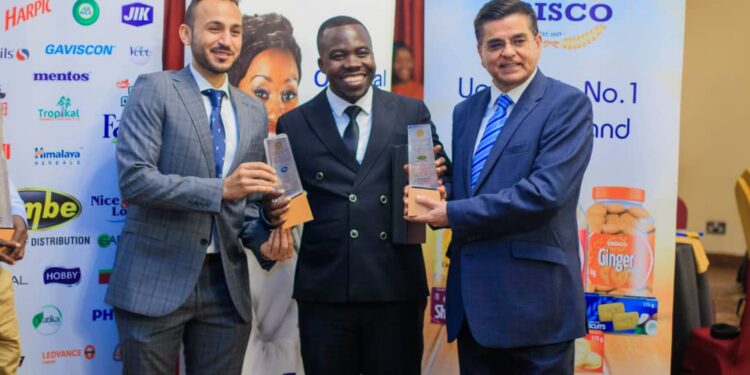 Dembe Group Managing Director, Adim Damani, Emmanuel Turyazooka Sales Manager Reckitt Uganda, and CEO of Dembe Group, Anil Damani pose with the award during the event.
