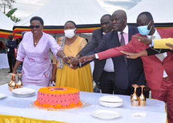 Hon. Babalanda joined by other government officials to cut a cake during the official opening of Bushenyi RDC Office