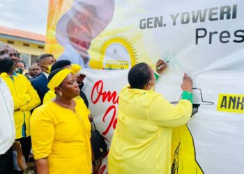 Minister Babalanda signing on President Museveni endorsement placard in Mbarara City on Friday