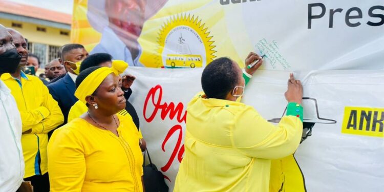 Minister Babalanda signing on President Museveni endorsement placard in Mbarara City on Friday
