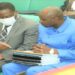 Hon. John Bosco Ikojo (R) confering with Minister David Bahati prior to his presentation of the committee report on the electricity loan