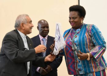 Minister Amongi receives her award from Prof. Syed Abidi of Makerere University