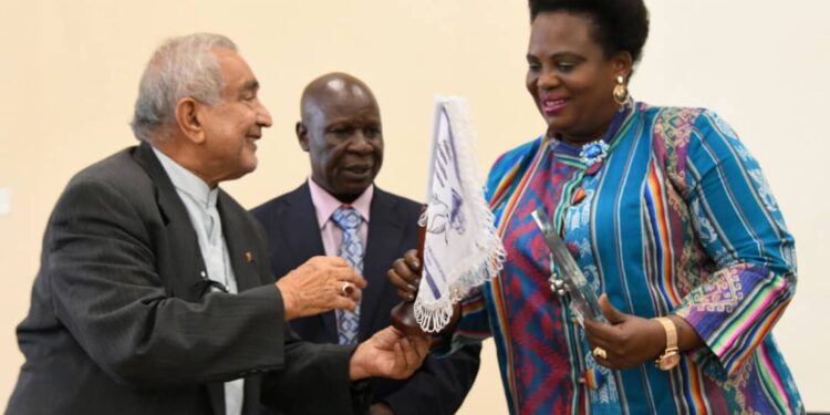 Minister Amongi receives her award from Prof. Syed Abidi of Makerere University