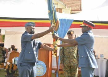 The outgoing CAF Lt Gen Charles Lutaaya (L) handing over the UPDF – Air Force service Flag to the new CAF Lt Gen Charles Okidi (R)