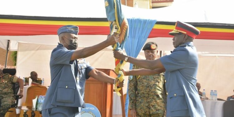 The outgoing CAF Lt Gen Charles Lutaaya (L) handing over the UPDF – Air Force service Flag to the new CAF Lt Gen Charles Okidi (R)