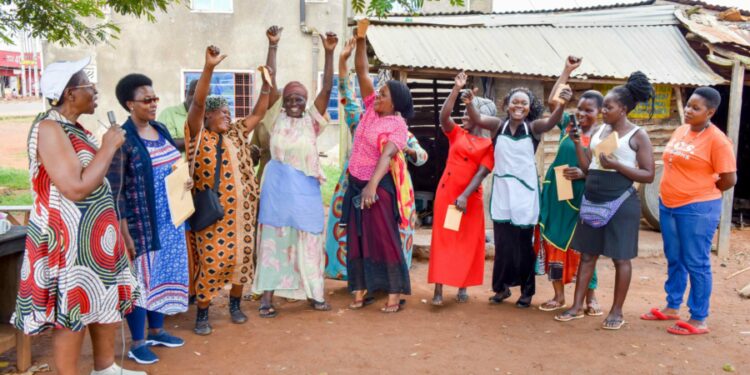 The State House Political desk Princess Pauline Nassolo (left) and Flora Kabibi (second left) in a group photo with very excited women from Bukoloto market while talking to them on how to embrace government programs in Kayunga district on 9th December 2022. Photo by PPU/ Tony Rujuta.