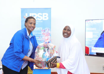 Freda Bwiizi, Director Research & Planning hands over a gift hamper to Faridah Asiimwe of UWEAL during the closure of URSB's Customer Engagement Week.