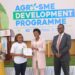 State Minister for Investment and Privatisation Hon. Evelyn Anite hands over a certificate to a participant in the Agro- SME development training at the closing ceremony as Post Bank Julius Kakeeto (right) looks on