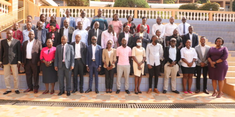 URSB Deputy Registrar General, Alex Anganya (2nd L) in a group picture with Tier IV Non Deposit Taking Institutions Representatives at Hotel Africana in Kampala.