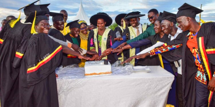The State House Comptroller Jane Barekye (center) cutting the cake with graduates, local leaders and teachers at the 1st graduation of the Presidential Initiative for Zonal Industrial Parks for Skills Development, Value Addition and Wealth creation at the Lango Zonal Industrial Hub in Lira district on 3rd January 2023. Photo by PPU / Tony Rujuta.
