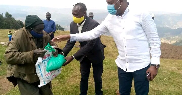 Hon. Kamuntu Gives Packed Maize Floor, beans and Soap to Mutwa at Rwamahano Village