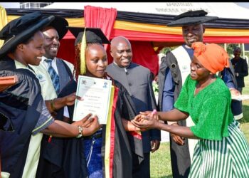 State House Comptroller Jane Barekye (L) presents a certificate to Mbambu Apophia and her mother for being, one of the best student at the Rwenzori Zonal Industrial Hub in Kasese as Hon Kiyonga looks on.