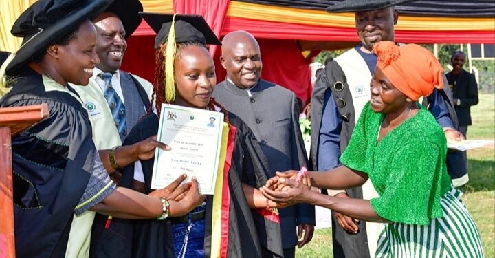 State House Comptroller Jane Barekye (L) presents a certificate to Mbambu Apophia and her mother for being, one of the best student at the Rwenzori Zonal Industrial Hub in Kasese as Hon Kiyonga looks on.