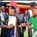 State House Comptroller Jane Barekye (L) presents a certificate to Mbambu Apophia and her mother for being, one of the best student at the Rwenzori Zonal Industrial Hub in Kasese as Hon Kiyonga looks on.