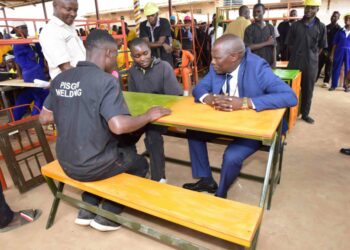 Minister of State for Kampala Capital City and Metropolitan Affairs Kyofatogabye Kabuye tries out  furniture made by the welding students as they have a chat during the Presidential Initiative on skilling the Girl/Boy Child project 7th intake inspection of the skills of the students as they show case their work at Wabigabo Centre on 15th February 2023. Photo by PPU/Tony Rujuta.
