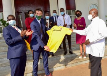 President Yoweri Museveni (right) hands over a Uganda Athletics Federation (UAF) official Jersey T- Skirt to a British sports commentator, television presenter and freelance reporter Robert Joseph Walker (center) in the presence of the Uganda Athletics Federation (UAF) President Dominic Otuchet (left) after a meeting with the Uganda Tourism Board (UTB) members at the State House Entebbe on 8th February 2023. Photo by PPU/ Tony Rujuta.