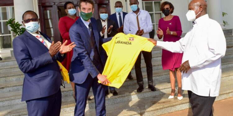 President Yoweri Museveni (right) hands over a Uganda Athletics Federation (UAF) official Jersey T- Skirt to a British sports commentator, television presenter and freelance reporter Robert Joseph Walker (center) in the presence of the Uganda Athletics Federation (UAF) President Dominic Otuchet (left) after a meeting with the Uganda Tourism Board (UTB) members at the State House Entebbe on 8th February 2023. Photo by PPU/ Tony Rujuta.