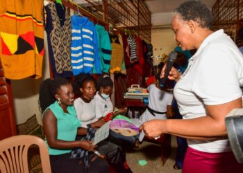 Presidential Initiative on skilling the Girl/Boy Child head of the project Faith Katana Mirembe (right)  interacting with knitting students as they show the skills attained in the course this was during the Presidential Initiative on skilling the Girl/Boy Child project 7th intake inspection of the skills of the students as they show case their work at Wandegeya Centre on 22nd February 2023. Photo by PPU/Tony Rujuta.