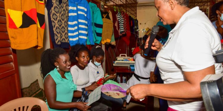 Presidential Initiative on skilling the Girl/Boy Child head of the project Faith Katana Mirembe (right)  interacting with knitting students as they show the skills attained in the course this was during the Presidential Initiative on skilling the Girl/Boy Child project 7th intake inspection of the skills of the students as they show case their work at Wandegeya Centre on 22nd February 2023. Photo by PPU/Tony Rujuta.