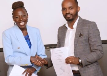 Maestro Studio's newly signed artiste Atyang Laura shares a handshake with the music label's CEO Francis Baguma after signing a lucrative recording contract