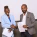 Maestro Studio's newly signed artiste Atyang Laura shares a handshake with the music label's CEO Francis Baguma after signing a lucrative recording contract