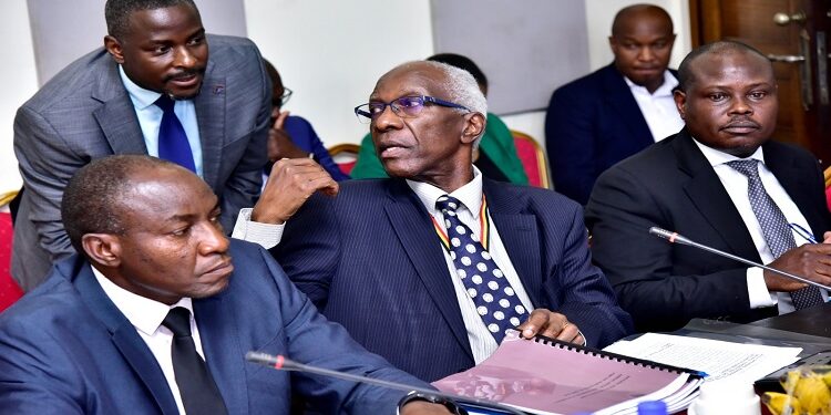 Auditor General, John Muwanga (C) consults one of his staff during the committee meeting