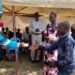 The Won Nyaci hands over soccer balls to different group leaders at Obot Primary School, Iceme sub county in Oyam District.