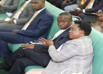 Minister Betty Amongi (R) in the House as the report was presented.