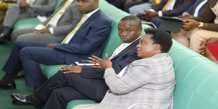 Minister Betty Amongi (R) in the House as the report was presented.