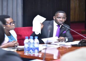 Hon. Ssenyonyi (R) shows the KCCA team a document containing the queries from the Auditor General