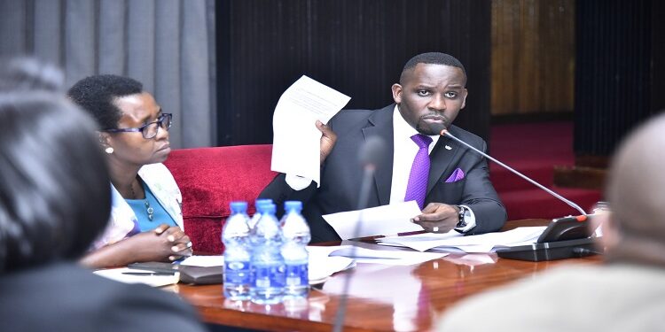 Hon. Ssenyonyi (R) shows the KCCA team a document containing the queries from the Auditor General