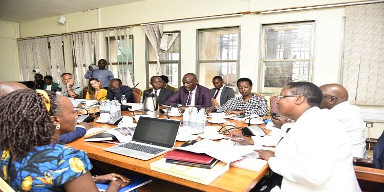 Hon. Nambooze (R) chairing the committee where UNRA Ed, Kagina (in black and white) appeared