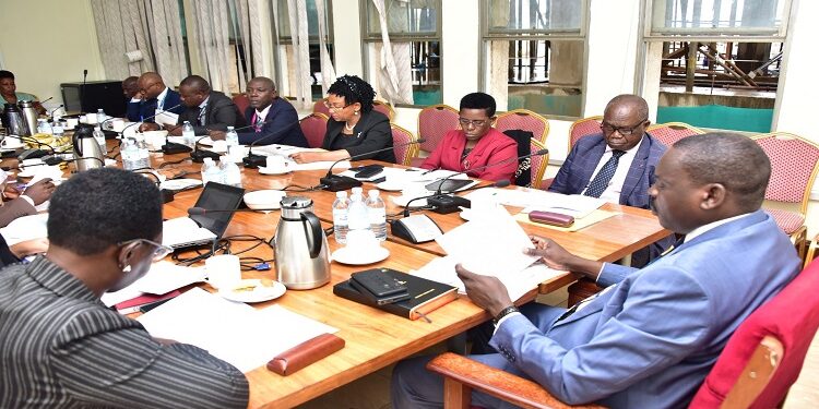 Hon. Muruli Mukasa (2nd R) appearing before the committee chaired by Hon. Onzima (R)