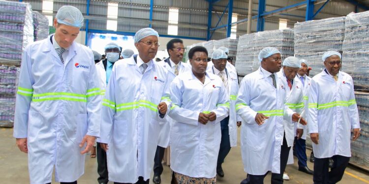 Left-Right: Eugene Willemsen, the PepsiCo CEO of the Africa, Middle East & South
Asia (AMESA) region; Dr. Amos Nzeyi, the Crown Beverages Limited Executive Chairman; The Vice President of Uganda, Rtd Major.
Jessica Alupo; Paddy Muramiirah, the CBL CEO and former Prime Minister of Uganda, Hon. Ruhakana Rugunda tour the newly
commissioned CBL bottling plant. At the back is Major General Jim Muhwezi Katugugu, the Cabinet Minister for National Security and
Hon. Mwebesa Francis, Minister of Trade Industry and Cooperatives.