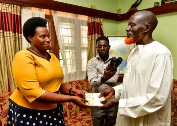 Mrs. Barekye handing over President Museveni's condolence message to the father of Isma Olaxess