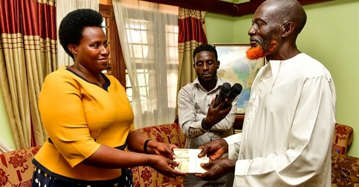 Mrs. Barekye handing over President Museveni's condolence message to the father of Isma Olaxess