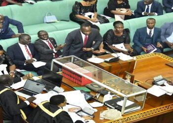 The LOP, Hon. Mpuuga stands on a point of procedure as Hon. Pacutho (satnding on the right) presents amendments to the bill