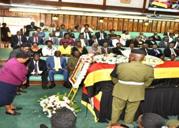 Premier Nabbanja pays her respects after laying a wreath on the coffin containing the body of Engola