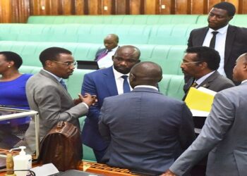 Attorney General, Kiryowa Kiwnuka (2nd L) chats with other MPs when the House was suspended for a break. He withdrew the bill on a new pension fund