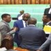 Attorney General, Kiryowa Kiwnuka (2nd L) chats with other MPs when the House was suspended for a break. He withdrew the bill on a new pension fund