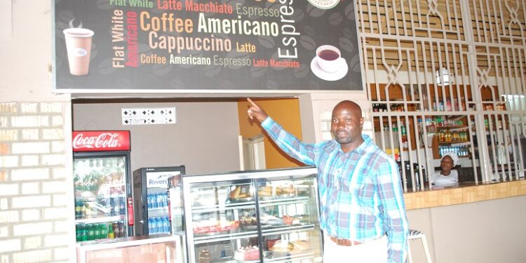 Charles Kirumira, the manager, Highway- Masaka, pointing at some of the drinks always asked for by customers. PHOTO BY BRIAN MUGENYI