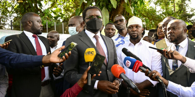 PPS Kenneth Omona speaks to the press at the State House gate in Nakasero where he received a banner from the people with messages wishing President Museveni a quick recovery. PPU Photo (1)