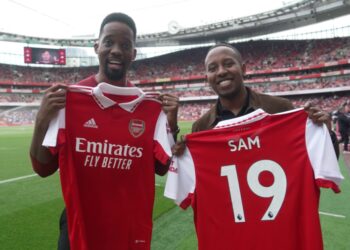 Adrian Ntwatwa winner of the Global Gooners competition, (M) poses for a picture with Sam Rugunda his friend (L) and Gilberto Silva) during the grand Emirates stadium tour, home of the Gooners. They were invited to watch the recent home game against Brighton & Hove Albion F.C.