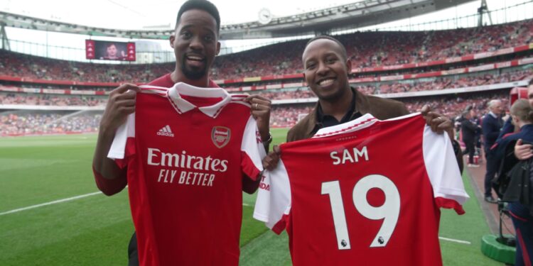 Adrian Ntwatwa winner of the Global Gooners competition, (M) poses for a picture with Sam Rugunda his friend (L) and Gilberto Silva) during the grand Emirates stadium tour, home of the Gooners. They were invited to watch the recent home game against Brighton & Hove Albion F.C.