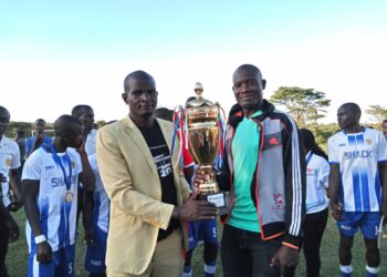 Coach Fred Kasekende with the St Henry's College Kitovu football team recently.