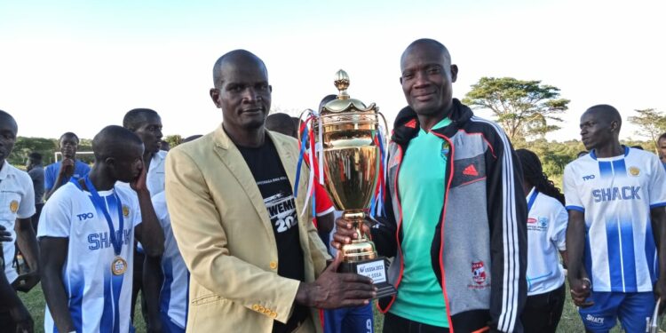 Coach Fred Kasekende with the St Henry's College Kitovu football team recently.