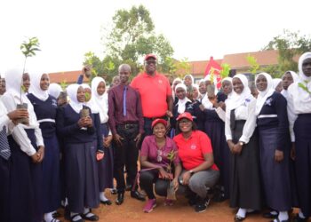 Mumba Kalifungwa, Absa Bank Uganda’s Managing Director (up in a red cap) poses for a photo with students of Highland Secondary School in Kisaasi on Tuesday. Photo@mumbaKalifungwa
