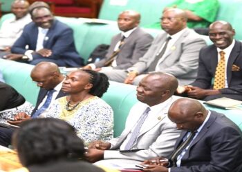 The leadership of the Committee on National Economy, Hon. John Bosco Ikojo (R) and Hon. Robert Migadde (2nd, R) seated with Ministers