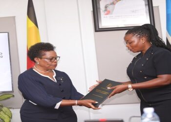 IGG Beti Kamya (L) hands over the report to Commissioner Afoyochan